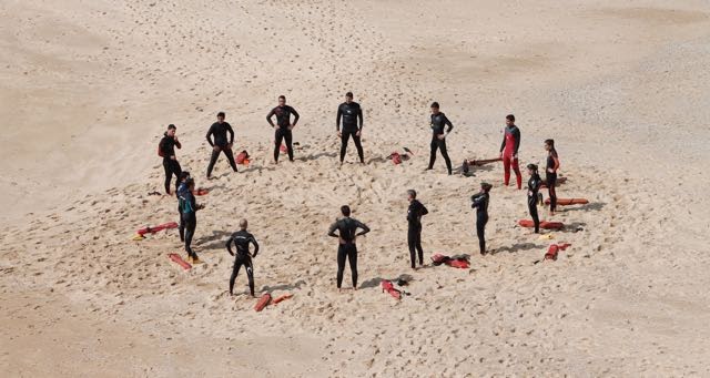 group of lifeguards in a circle on the beach