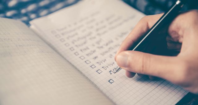 making a checklist on a notepad